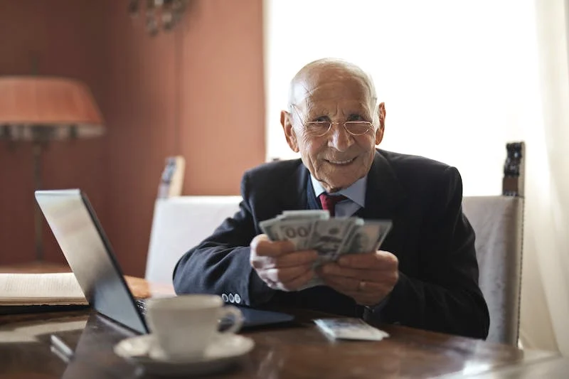 A wisdom man holding money earned from investing